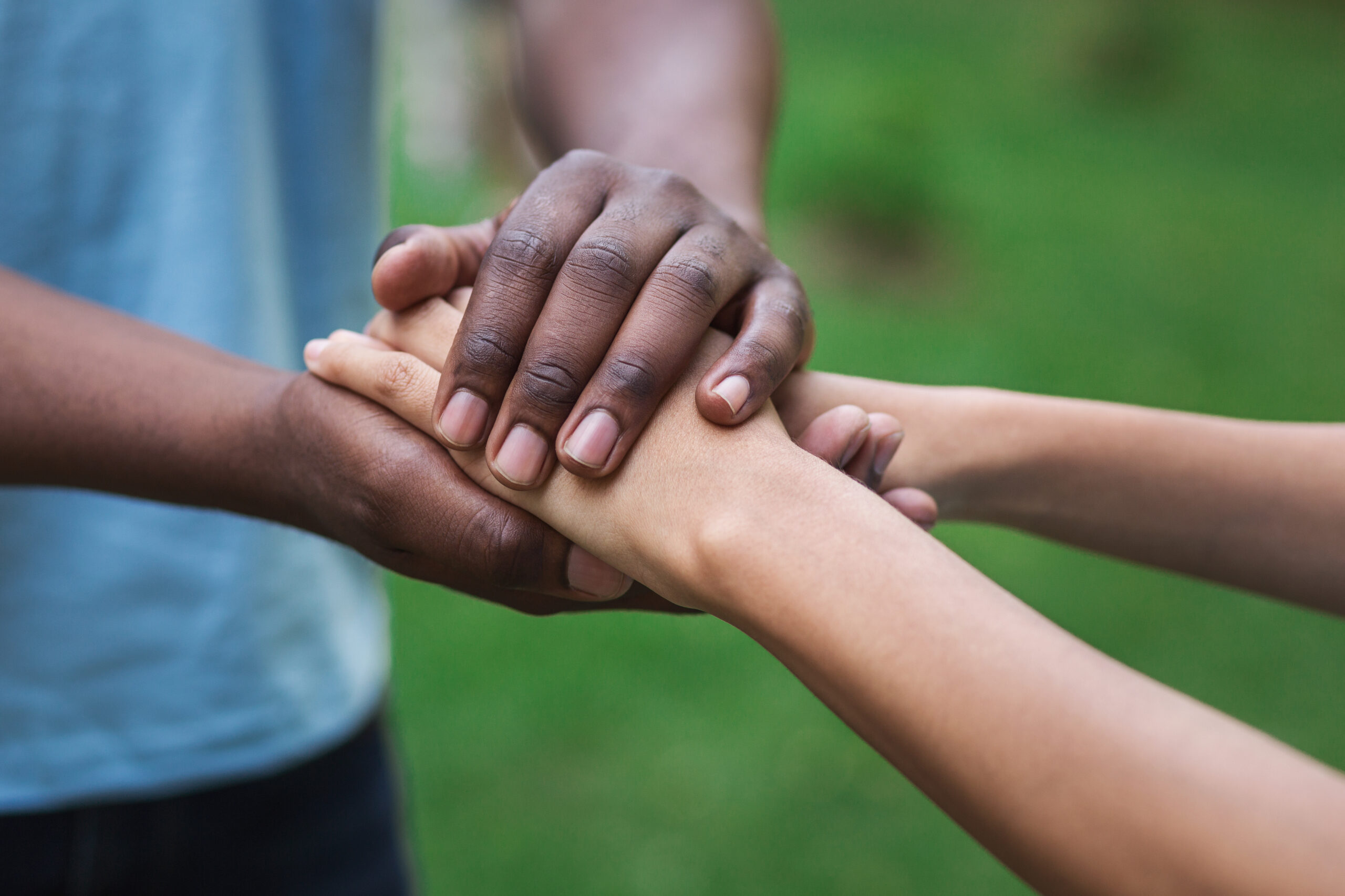 Black caregiver supporting woman, holding her hand outdoors. Philanthropy, kindness, volunteering concept, copy space